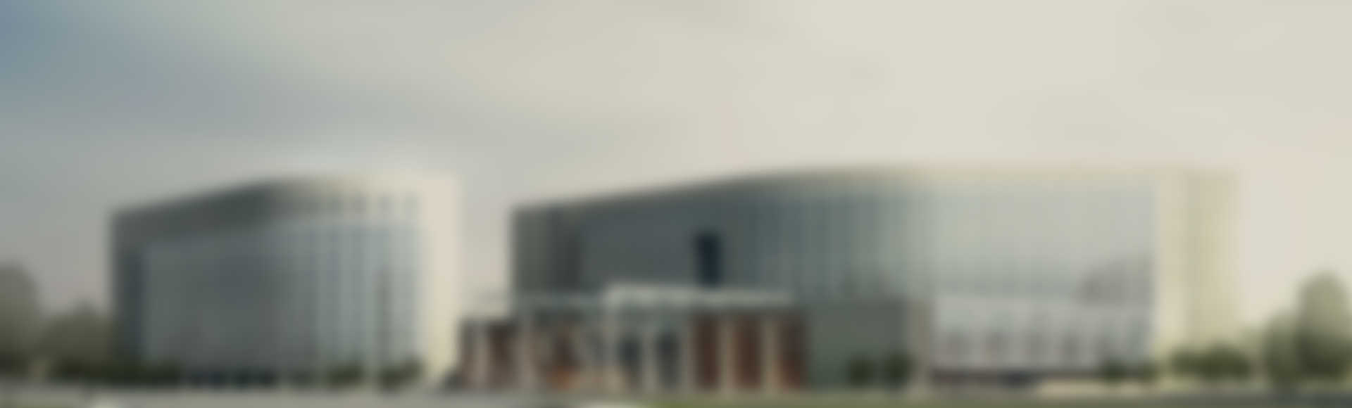 Two modern office buildings with a central entrance under a cloudy sky.